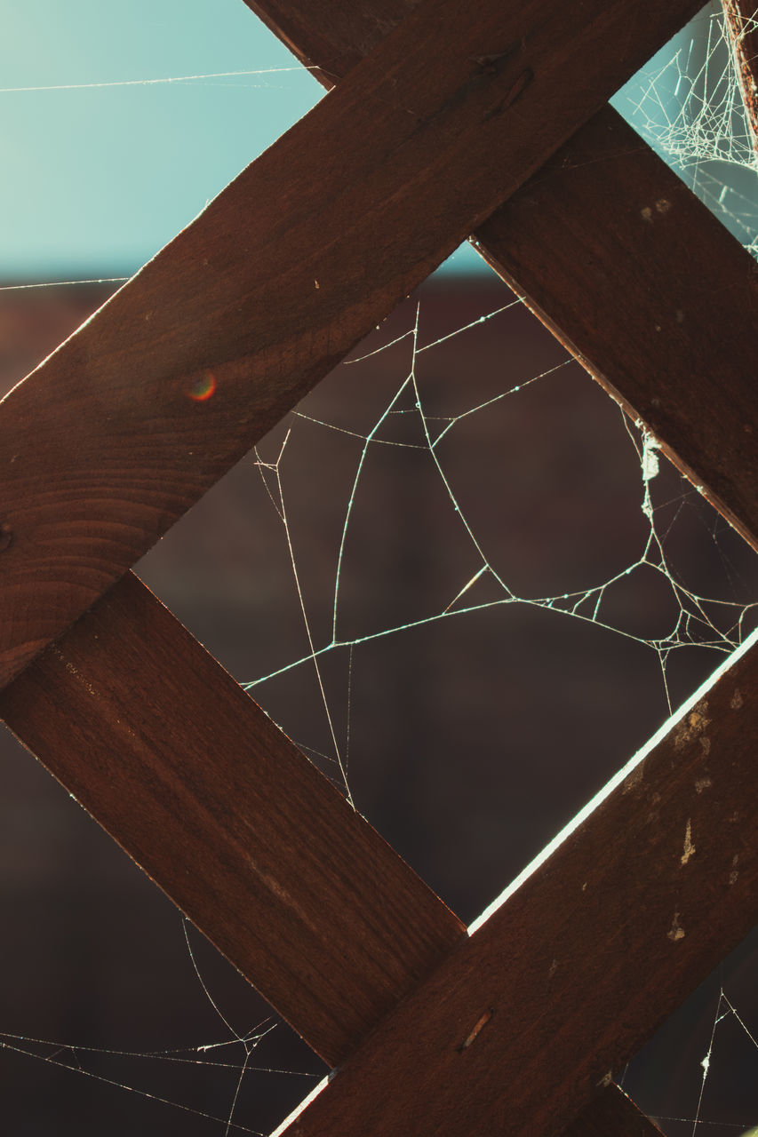 LOW ANGLE VIEW OF SPIDER WEB ON METALLIC STRUCTURE