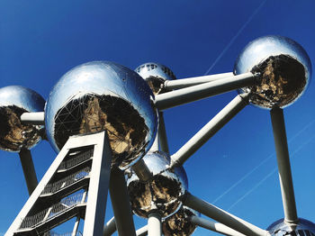 Low angle view of metallic structure against blue sky