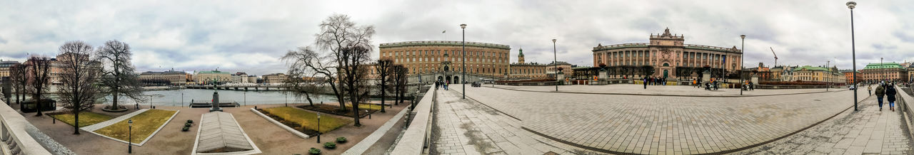 Panoramic view of buildings against cloudy sky