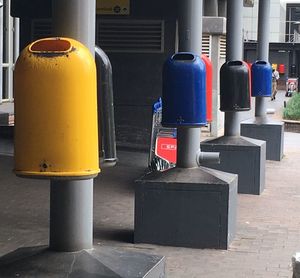 Close-up of garbage can on sidewalk in city