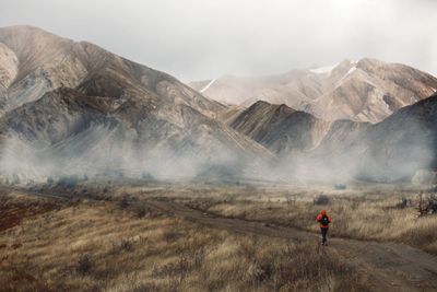 Rear view of man with mountain range in background