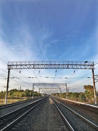 Railroad tracks by road against sky