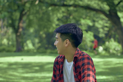 Portrait of young man looking away outdoors