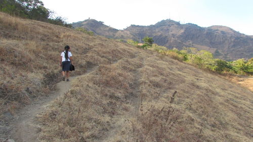 Rear view of man walking on field