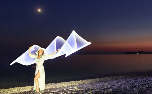 Man in sea against clear sky at night