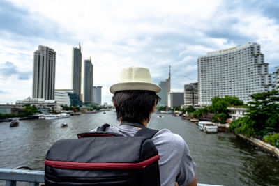 Rear view of man in city against sky