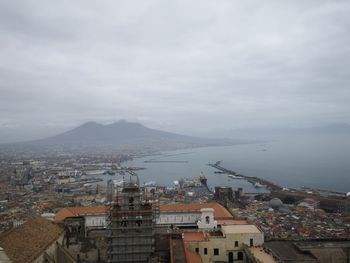 High angle view of townscape by sea against sky