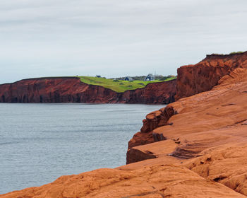 Rock formations by sea against sky