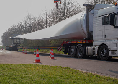 Vehicles on road against sky in city