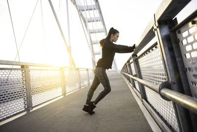 Full length of woman standing on bridge