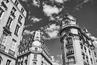 Low angle view of buildings against cloudy sky