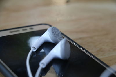 Close-up of in-ear headphones on smart phone