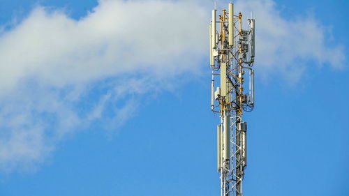 Low angle view of communications tower against blue sky