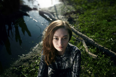 High angle portrait of woman sitting by lake