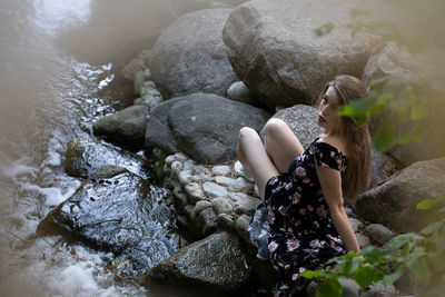 High angle view of woman sitting on rock