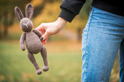 Midsection of woman holding stuffed toy outdoors