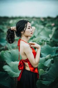 Young woman looking away while standing outdoors