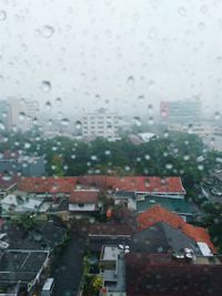 Buildings seen through wet window during rainy season