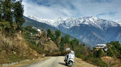 Road by mountains against sky