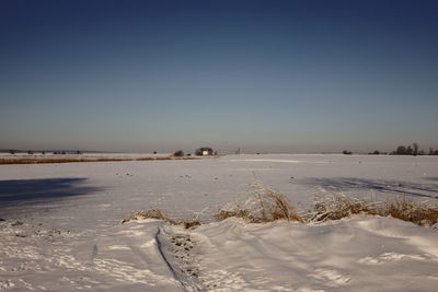 Scenic view of land against clear sky during winter