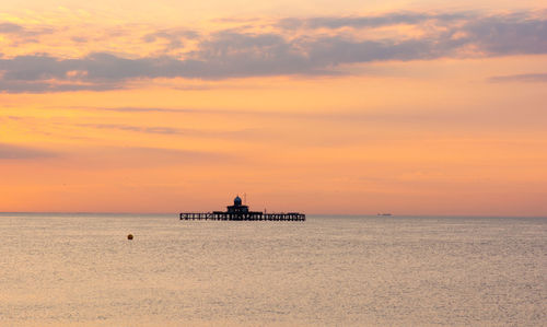 Scenic view of sea against orange sky