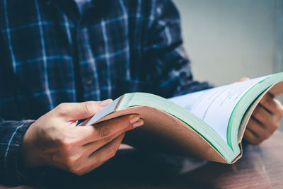 Midsection of man holding book