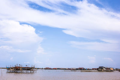 Scenic view of sea by buildings against sky