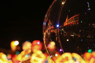 Close-up of illuminated ferris wheel at night