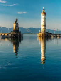 Lighthouse by lake against sky