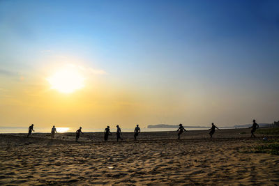 People playing on sand at beach