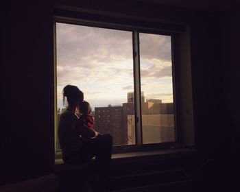 Mother with child sitting in front of window