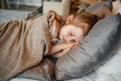 Sleeping satisfied little girl on a gray bed. high quality photo