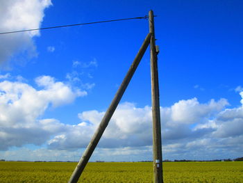 Low angle view of poles on field against sky