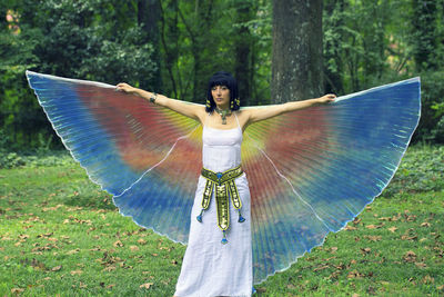 Woman in angel costume standing on field