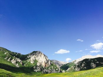 Scenic view of mountains against blue sky