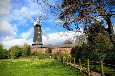 Traditional windmill on field against sky