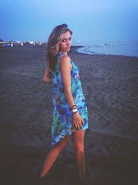 Portrait of young woman standing on beach