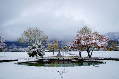 Pond amidst snowcapped field during winter