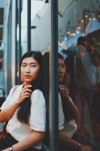 Young woman looking through window