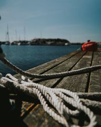 Close-up of rope tied to bollard against sky