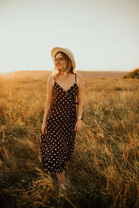 Young woman standing against sky