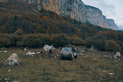 Cars on rocks by land against mountain