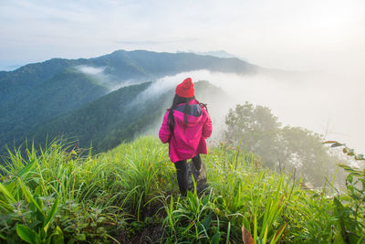 Woman looking at mountains against sky