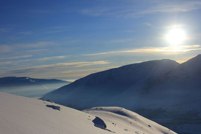 Scenic view of snowcapped mountains against sky during sunset
