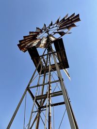 Low angle view of windmill against clear blue sky