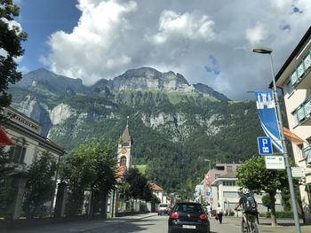 Road amidst buildings in city against sky