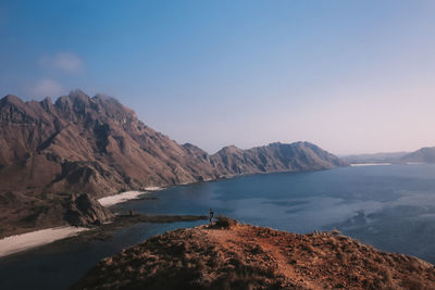 Scenic view of sea and mountains against clear sky