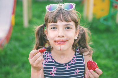 Portrait of cute girl eating strawberry