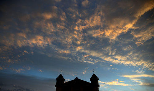 Low angle view of silhouette building against sky during sunset