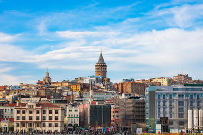 Buildings in city against cloudy sky